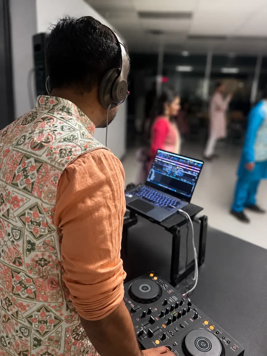 DJ H3T mixing music while guests celebrate in the background